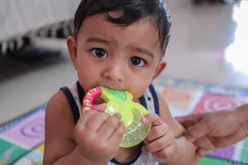 Anak memakan mainannya