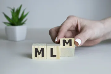 Wooden letters spelling MLM, business mlm concept