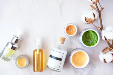 Natural skincare cosmetic products on white marble table from above. Creams, balms, masks, oils, serums.   Beauty blogger concept