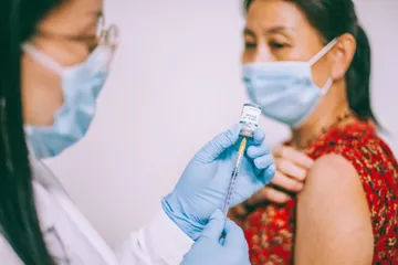 Perempuan mendapatkan suntikan vaksin Covid-19