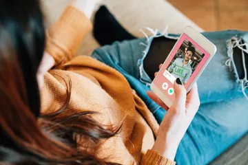 Ilustrasi perempuan sedang menggunakan aplikasi kencan online.