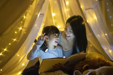 Membacakan dongeng untuk anak sebelum tidur.