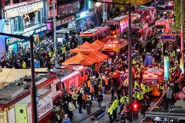 Pengunjung, polisi, dan paramedis berkumpul di lokasi tragedi Halloween Itaewon di Seoul, Korea Selatan, Minggu (30/10/2022) dini hari. Puluhan orang mengalami gagal jantung setelah berhimpitan di gang sempit untuk merayakan Halloween