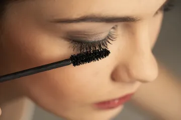 Perempuan yang sedang menggunakan maskara.