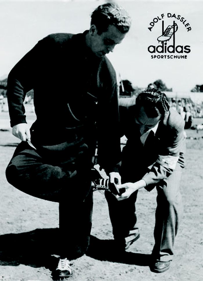 Adolf Dassler examines adidas sneakers.