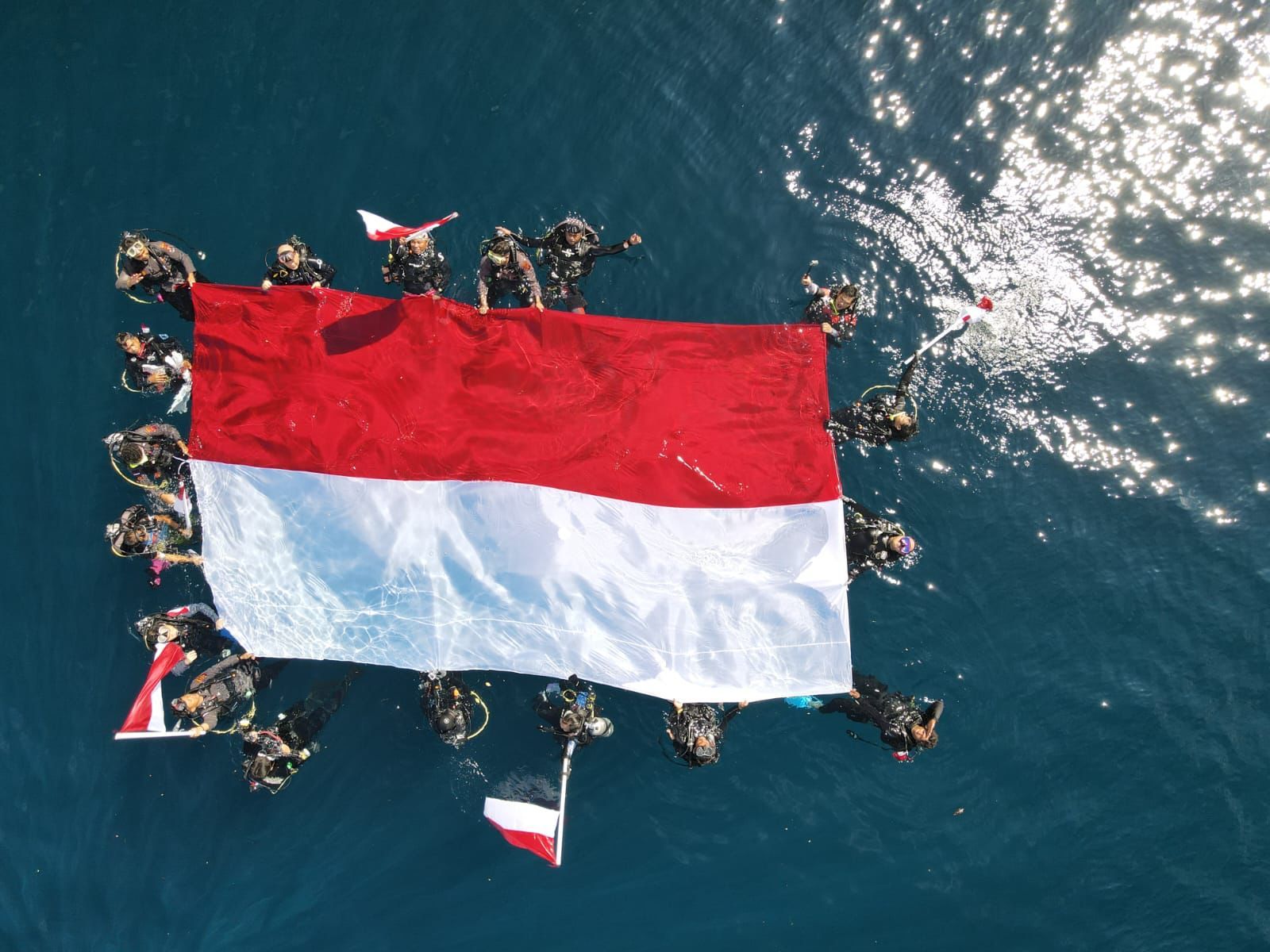Pengibaran bendera Merah Putih di bawah laut Berau.
