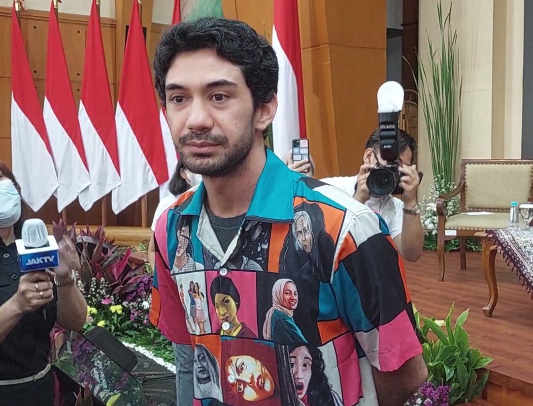 Aktor Reza Rahadian mengenakan kemeja dengan berbagai gambar karakter-karakter perempuan ikonik di film.