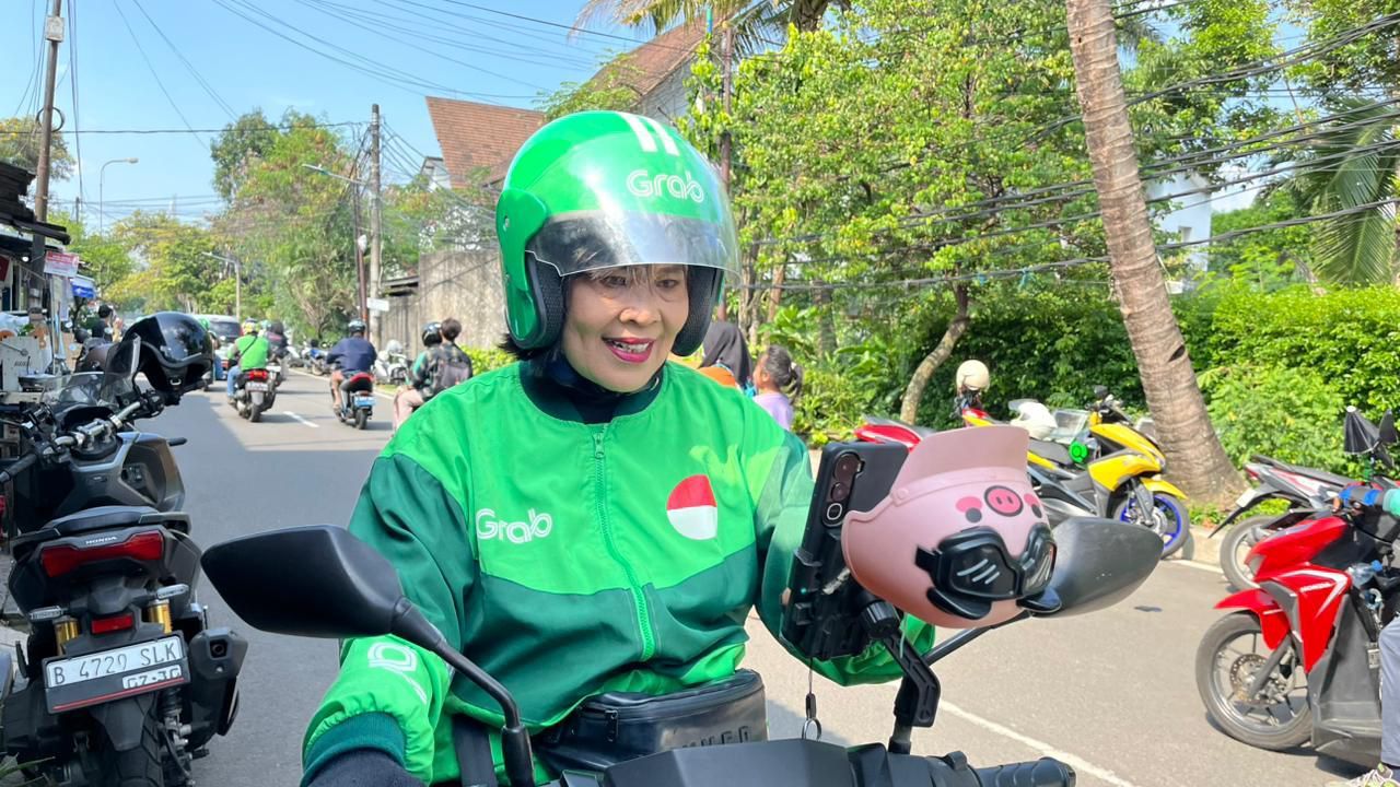 Mak Netty, Mitra Pengemudi GrabBike, tetap melangkah di tengah berbagai tantangan hidup, memanfaatkan  GrabModal by OVO Finansial untuk membantu suami berobat dan memenuhi kebutuhan keluarga sehari-hari  
